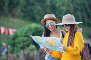 Duas mulheres jovens olhando um mapa sobre o que fazer em Guararema.