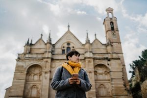 Mulher em frente a uma catedral por conta da sua viagem de turismo religioso.