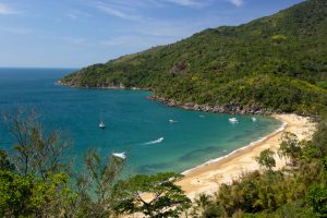 Praia secreta com mar azul e montanhas verdes, um dos lugares em Ilhabela.